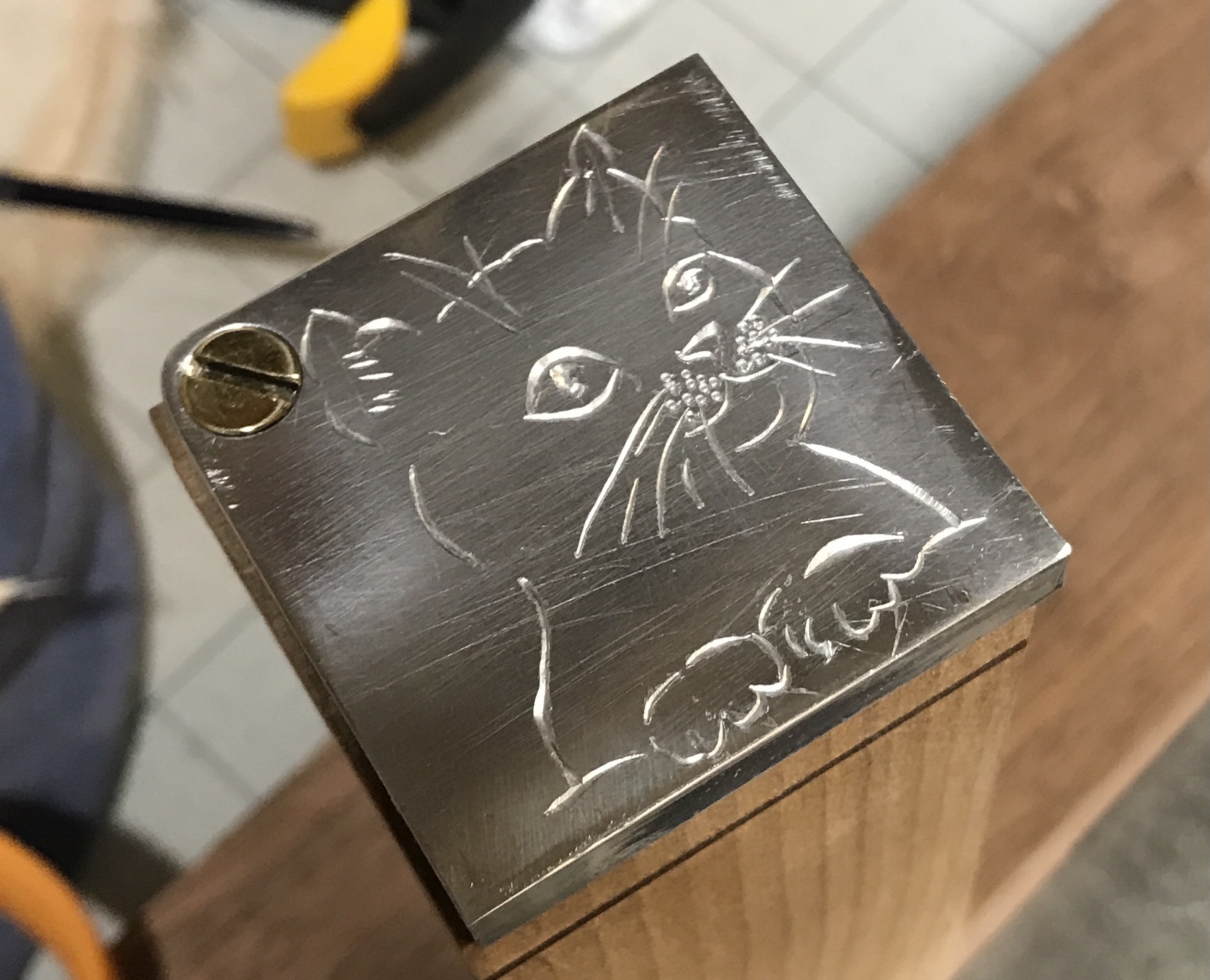 The cat sketch engraved on the top.